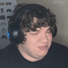 a man with curly hair wearing headphones with the hashtag @matchu on the bottom