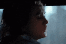 a close up of a woman 's face in a dark room .