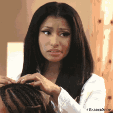 a woman is getting her hair braided at a barbershop