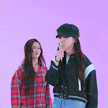 a girl eating an ice cream cone while another girl looks on