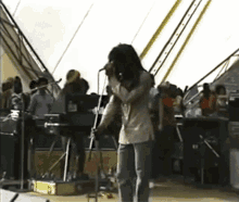 a man with dreadlocks is singing into a microphone