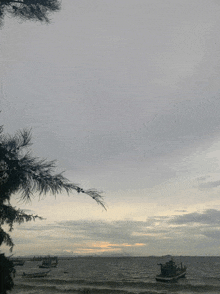 a few boats in the water with a cloudy sky behind them