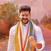 a man with a red star on his forehead is wearing a white shirt and a scarf around his neck