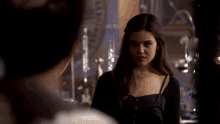 a woman is standing next to a man in a dark room .