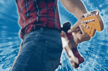 a man in a plaid shirt is holding an electric guitar