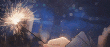 a person is holding a sparkler in their hand against a blue sky