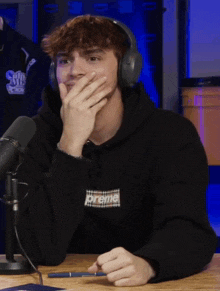 a young man wearing headphones and a black hoodie with the word prime on it
