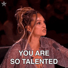 a woman with dreadlocks is sitting in front of a microphone and says you are so talented