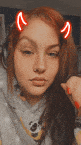 a girl with red hair and devil horns on her head