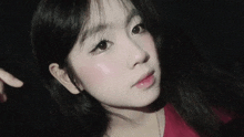 a close up of a girl 's face with a red shirt