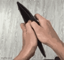 a person is holding a pen in their hands while holding a wallet .