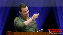 a man stands behind a podium that says dungeons & dragons adventures on it