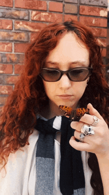 a woman with red hair is holding a butterfly