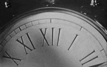 a black and white photo of a clock with roman numerals including xii and ii