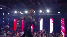 a wrestler is giving a devil horns sign while standing in a ring .