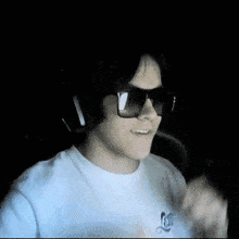 a man wearing sunglasses and a white shirt is making a peace sign