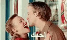 a man is kissing a woman on the cheek while laughing .