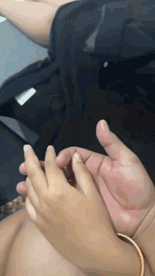 a close up of a person 's hands with a black shirt on