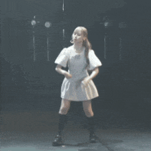 a woman in a white dress is standing in front of a microphone on a stage .