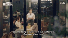 a woman is standing in a restaurant talking to customers