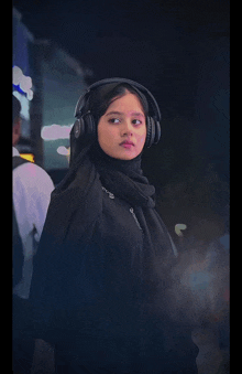 a woman wearing headphones and a black scarf