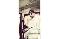 a man wearing sunglasses and a hat is holding a gun