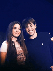 a man and a woman are standing next to each other on a stage