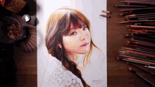 a drawing of a woman with a braided hair is on a table with colored pencils