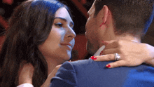 a man and a woman are kissing and the woman has red nails