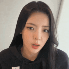 a woman with long hair is wearing a black hoodie