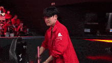 a man wearing glasses and a red jacket is making a heart shape with his hands