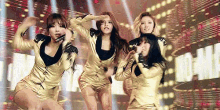 a group of women are dancing on a stage in front of a crowd .
