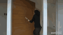 a woman is standing in front of a wooden door that is made by animatica