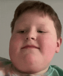 a close up of a young boy making a funny face with his mouth open .