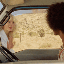 a man and a woman are sitting in a car and talking