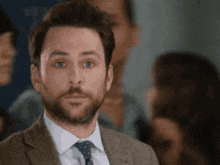 a man in a suit and tie is looking at the camera