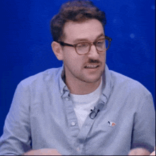 a man wearing glasses and a blue shirt with a fox on it