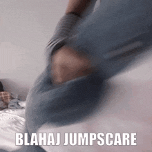 a blurry picture of a person jumping on a bed with the words blahaj jumpscare written on it .