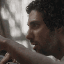 a close up of a man 's face with a beard looking at something