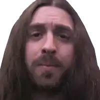 a man with long hair and a beard making a funny face