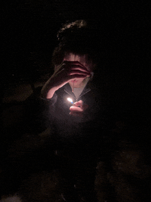 a person is holding a lighter in their hand in the dark