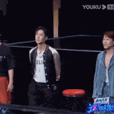 a man in a celine jacket is standing next to two other men