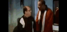 two men are talking to each other in a room .