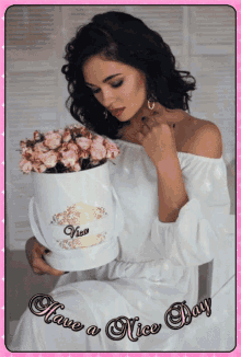 a woman in a white dress is holding a box of flowers with the words have a nice day written on the bottom