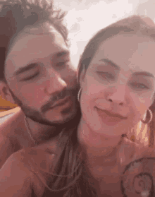 a man and a woman are posing for a picture and the woman is kissing the man on the cheek .