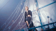 a woman is standing on a boat with ropes hanging from it