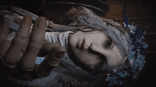 a doll with long white hair and blue flowers on her head