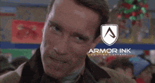 a man is smiling in front of a shield that says armor ink