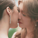 a close up of two women kissing with the caption lingerwgifss on the bottom
