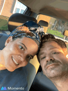 a man and a woman are sitting in a car with the word momento on the bottom right
